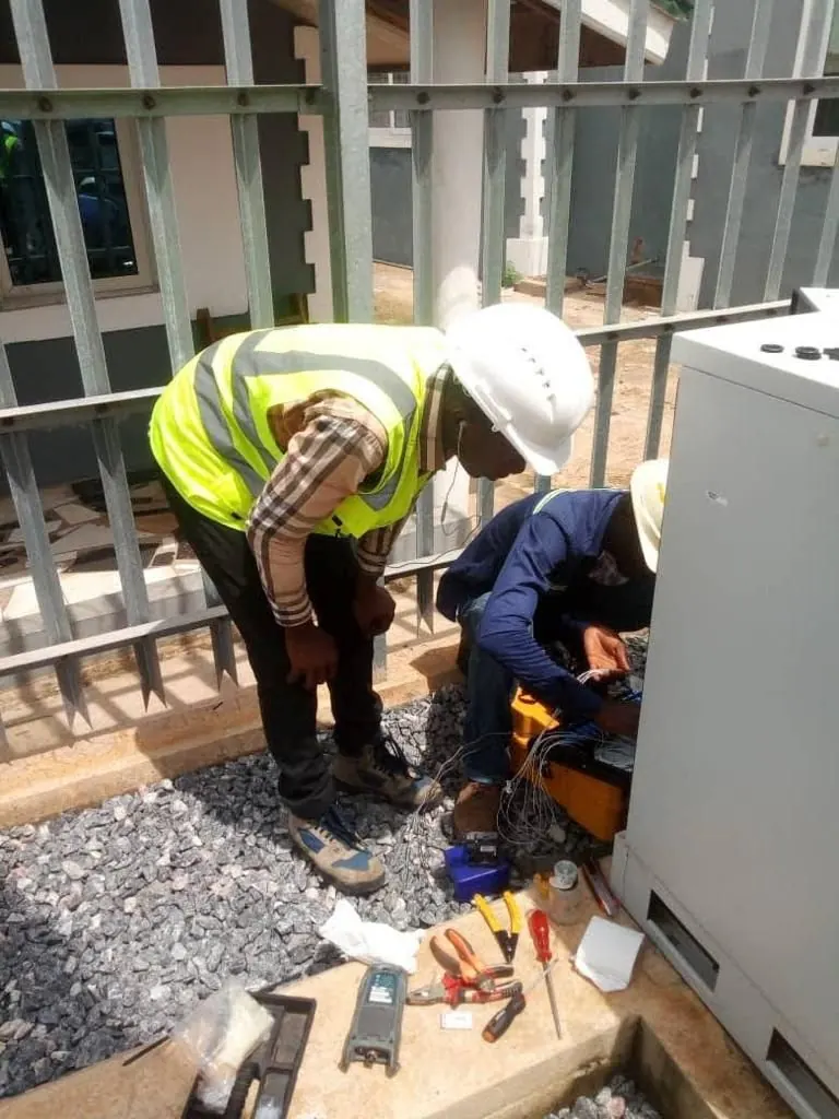 Engineers commissioning equipment inside a base station cabinet