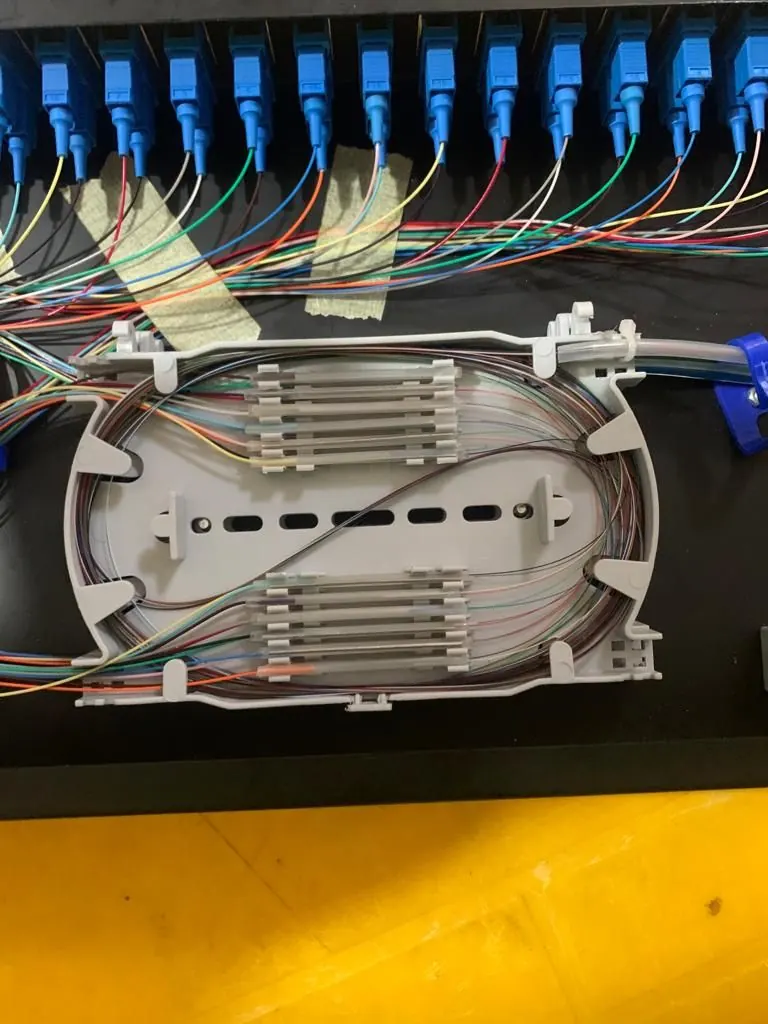 Open fibre splice closure showing colour-coded fibre trays