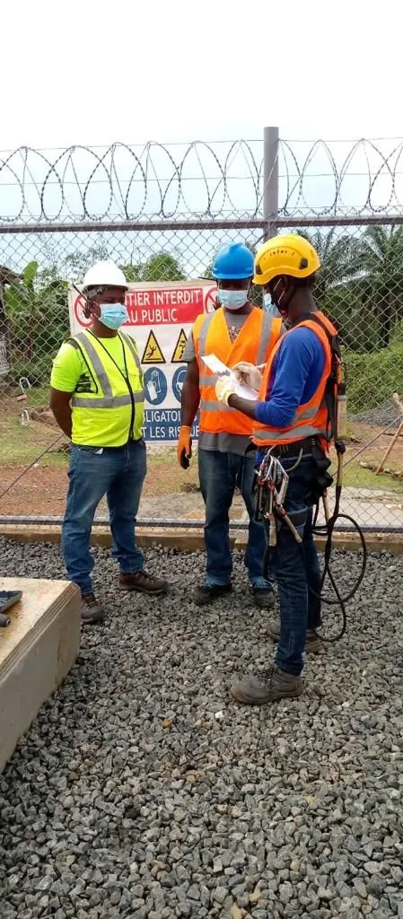 Site crew in full PPE beside the project safety signage board